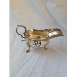 A Georgian-style cream boat, the base inset with a silver sixpence dated 1745 - 4.5" long -