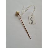 A gold pearl topped stick pin