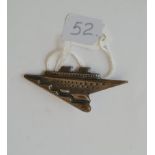 A metal brooch depicting a sailing ship with signature on reverse
