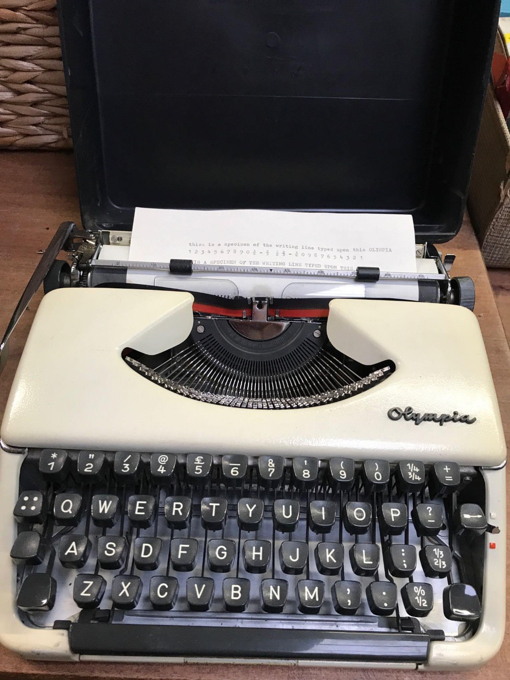 OLYMPIA CASED PORTABLE TYPEWRITER WITH METAL COVER