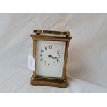 A brass timepiece (with key) with glass panels - 4.5" high