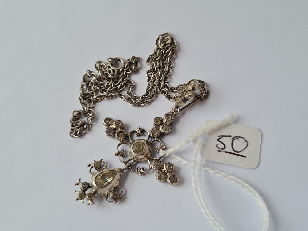 An antique silver paste set pendant on a silver chain