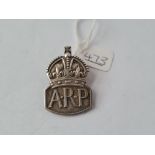 A silver ARP badge