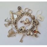A heavy silver charm bracelet with numerous charms 70g