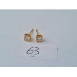 A pair white stone stud earrings in 18ct gold mounts 1.4g inc