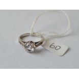 A dress ring with large central white stone with smaller on shoulders in 9ct