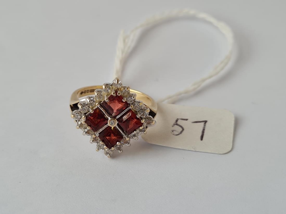 A dress ring with red & white stones set in a square pattern inn 9ct