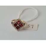 A dress ring with red & white stones set in a square pattern inn 9ct
