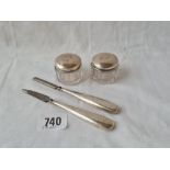 Two silver topped jars and two manicure items.