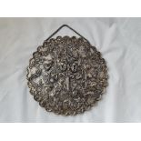 A Turkish mirror the reverse chased with a vase of flowers 8 inches diam