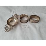 A two handled tea strainer and two napkin rings 94 gms