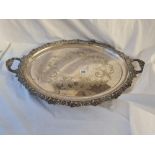 A oval two handled tray with a flower motif boarder 24 inches wide