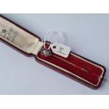 A boxed art deco gold & platinum stick pin set with ruby's, emeralds & diamonds
