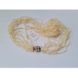 AN ANTIQUE NATURAL SEED PEARL 12 ROW NECKLACE STRUNG ONTO AN ANTIQUE 4 PEARL GOLD CLASP - 19" long