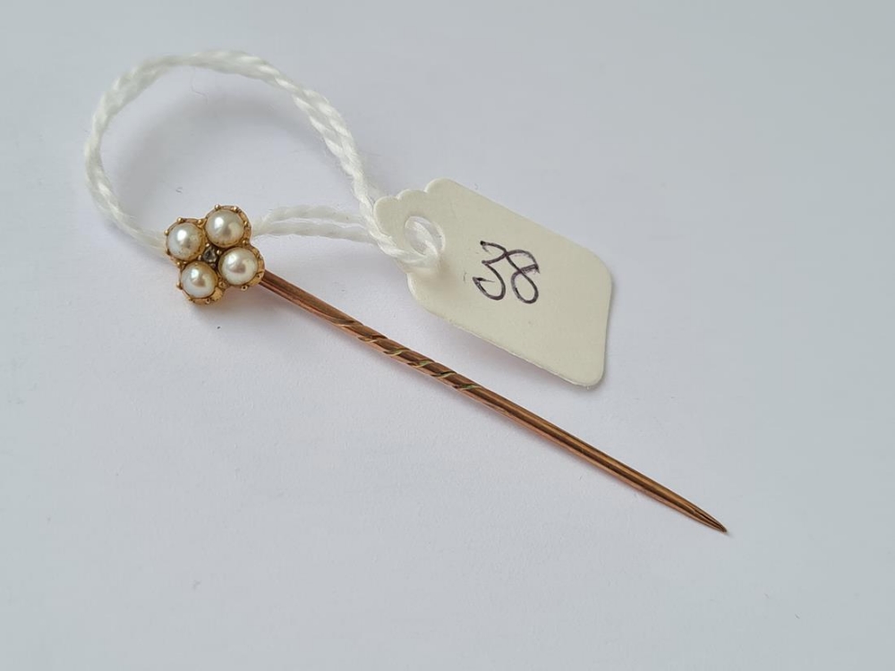 A small gold and pearl stick pin