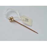 A small gold and pearl stick pin