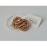 A vintage double knot brooch set with pearls with registration number 90554 set in high carat