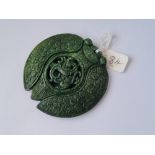 A large carved greenstone pendant with dragon motif to centre 75g