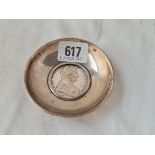 A circular dish inset with a silver coin dated 1780 3 1/2 inches dia 89 grms