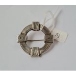 A silver circular Victorian brooch with engraved decoration