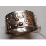 A silver wide bangle with gold overlay