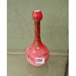 An onion shaped pink glass vase overlaid with flowering plant - 8" high