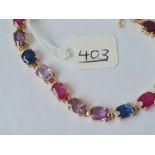 A PRETTY 19 STONE FANCY COLOURED SAPPHIRES LINE BRACELET IN 9CT - 8" long with clasp - 11.9gms