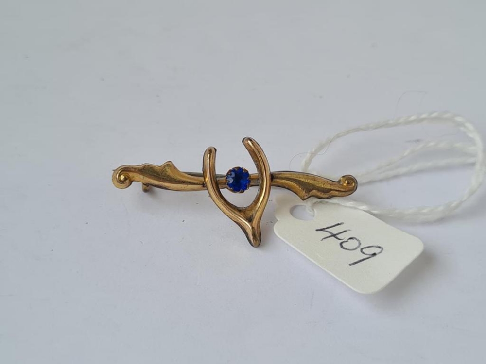 A wishbone bar brooch with single single blue stone