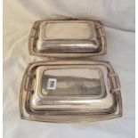 A pair of deco style entree dishes with covers