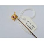 A stick pin with a pink almandine knot terminal in 15ct gold