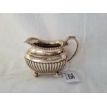 A oblong cream jug with half fluted body on ball feet Sheffield 1898 by JD & S 108 gms