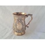 A Victorian embossed pint mug leaf capped handle 5 1/2 inches high London 1872 by TS 334 gms