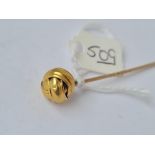 A stick pin set with a ball of string terminal in high carat gold