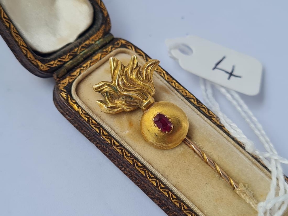 A cased gold grenade terminal stick pin with garnet - case dated Aug 25th 1898
