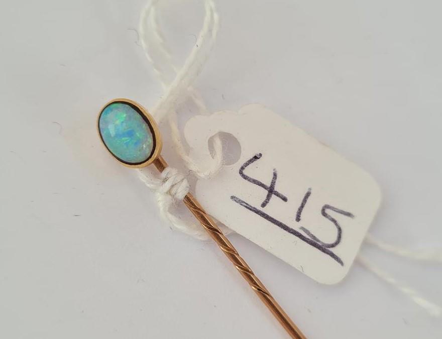 A opal mounted stick pin in gold