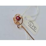 A gold stick pin with single garnet