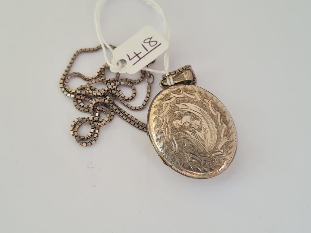 A silver engraved oval silver locket necklace