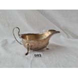 A oval silver jubilee sauce boat on 3 pad feet 5 3/4 inches over handle London 1935 by EV 111 gms