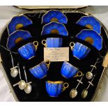 A boxed Coal port coffee set in blue and gilt with silver and enamelled spoons