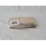 A glasses case with hammered finish with a pair of spectacles in the case B'ham 1931