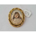 A Victorian hand painted miniature of a young girl in a yellow metal frame