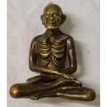 A Eastern brass figure of seated man 3 inches high