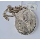 A very large silver locket (5.5cm long) with floral scroll decoration on silver chain