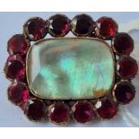 A antique mourning brooch surrounded by 14 good garnets set in gold