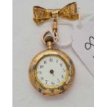 A gold and enamelled ladies fob watch in 14ct gold with 9ct ribbon bow suspension