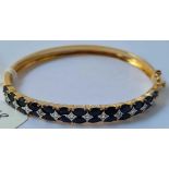 A good silver gilt bangle set with two rows of black sapphires and diamonds