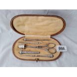 A white metal sewing set in fitted case