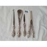 Four silver handled button hooks shoe horn etc.