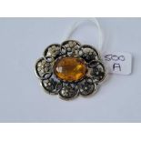 A white metal fancy brooch with central yellow stone