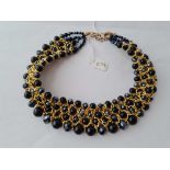A black bead and gilt metal four row chocker necklace